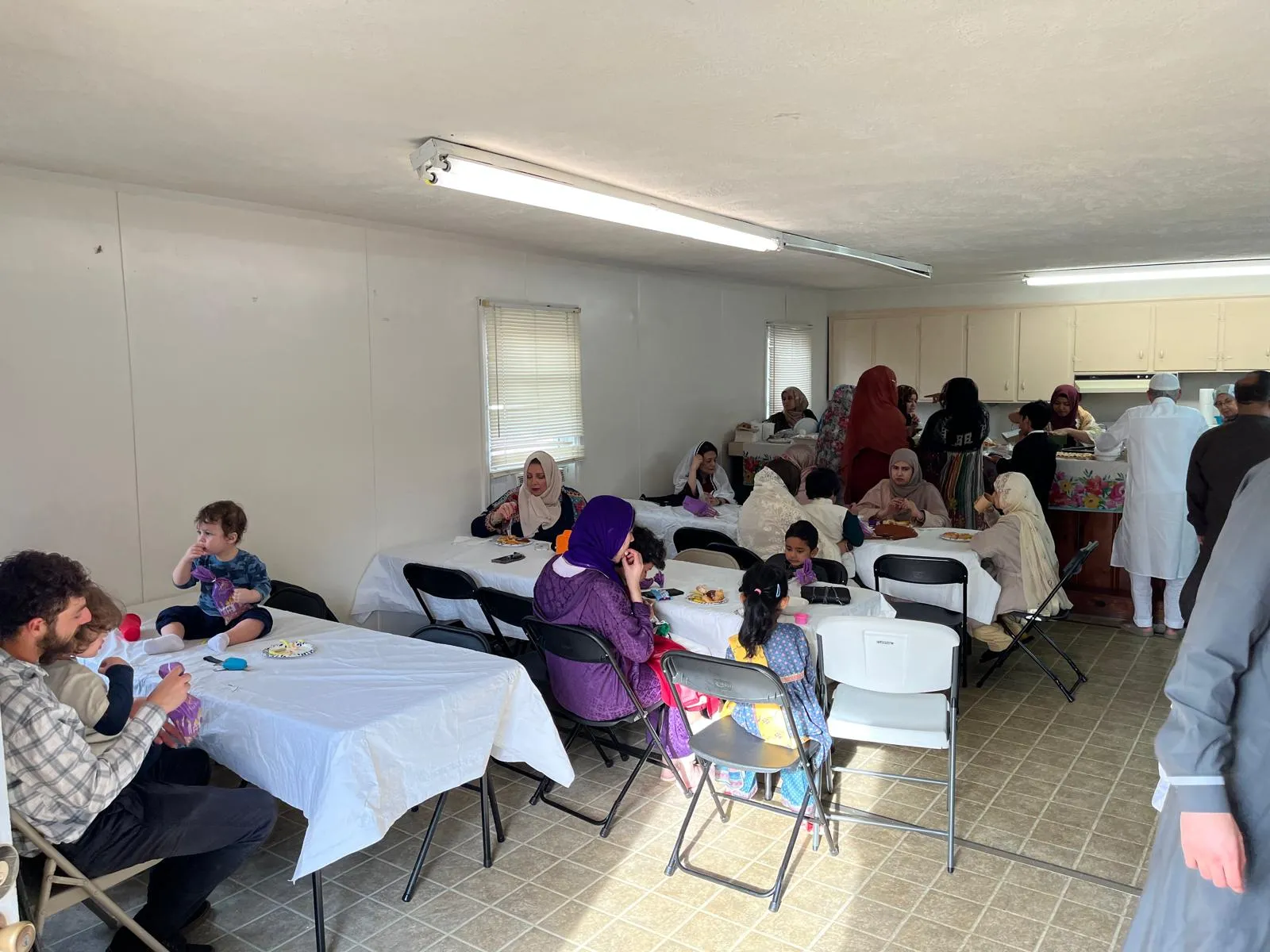 Families sharing a meal in the social hall
