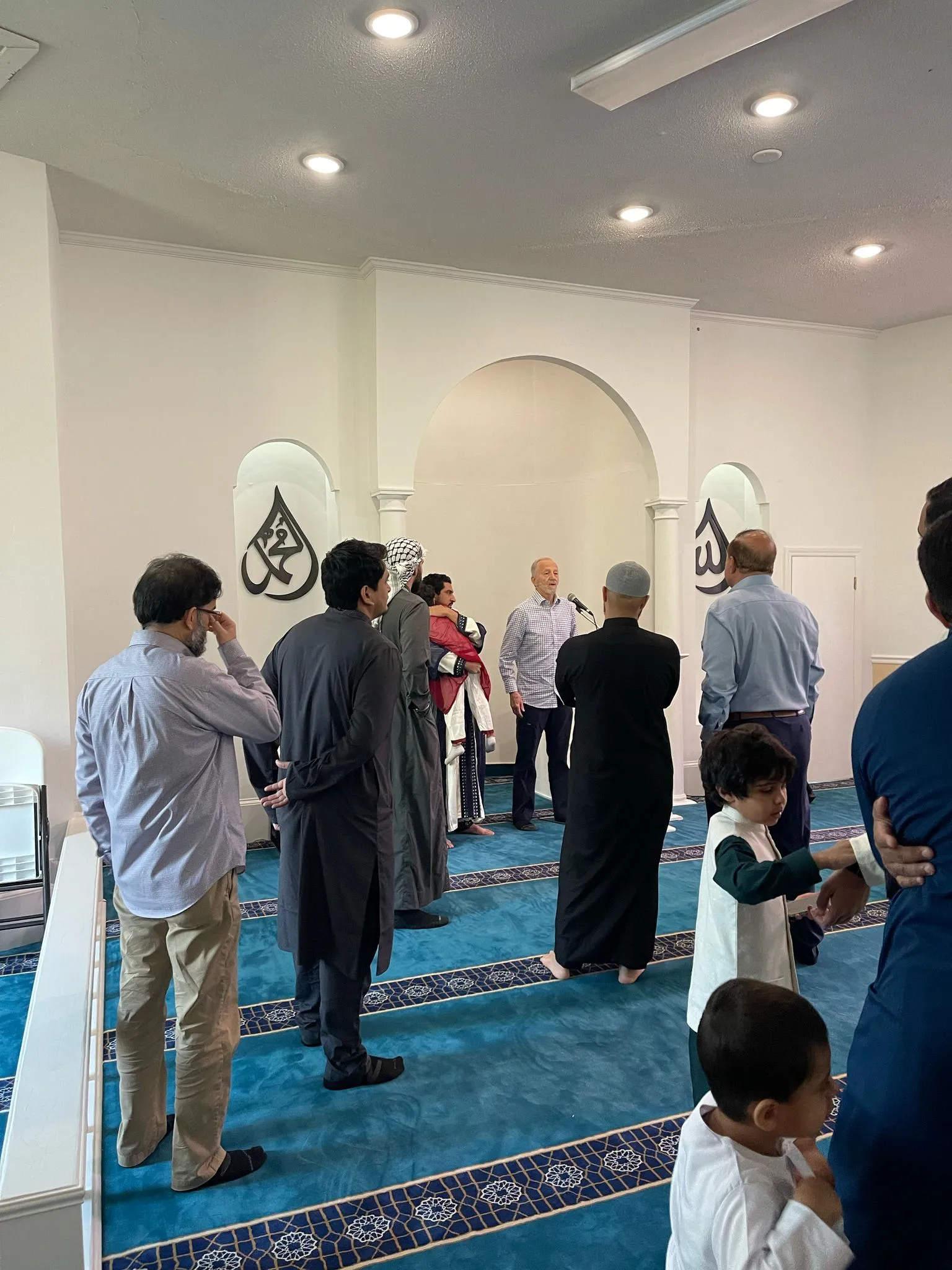 Neighbors and visitors talking in the prayer hall